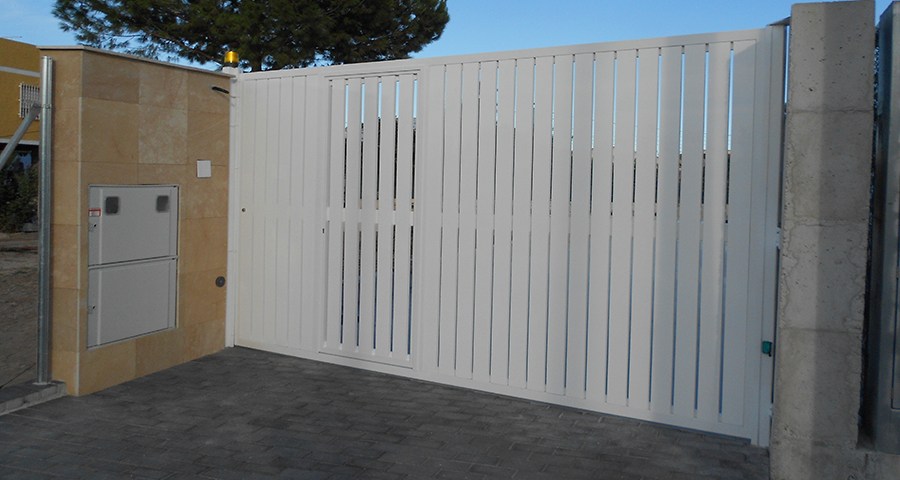 PUERTA ABATIBLE DE UNA HOJA CON PUERTA DE SURTIDERO CON ESTRUCTURA DE HIERRO GALVANIZADO Y RECTANGULARES DE ALUMINIO.